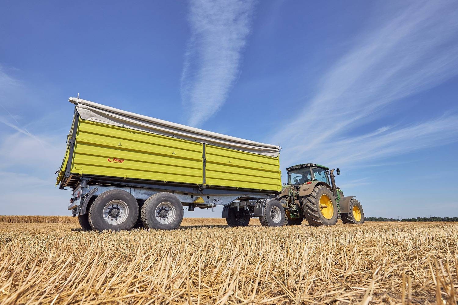 Třístranný sklápěč na poli s traktorem Třístranný sklápěč na poli s traktorem