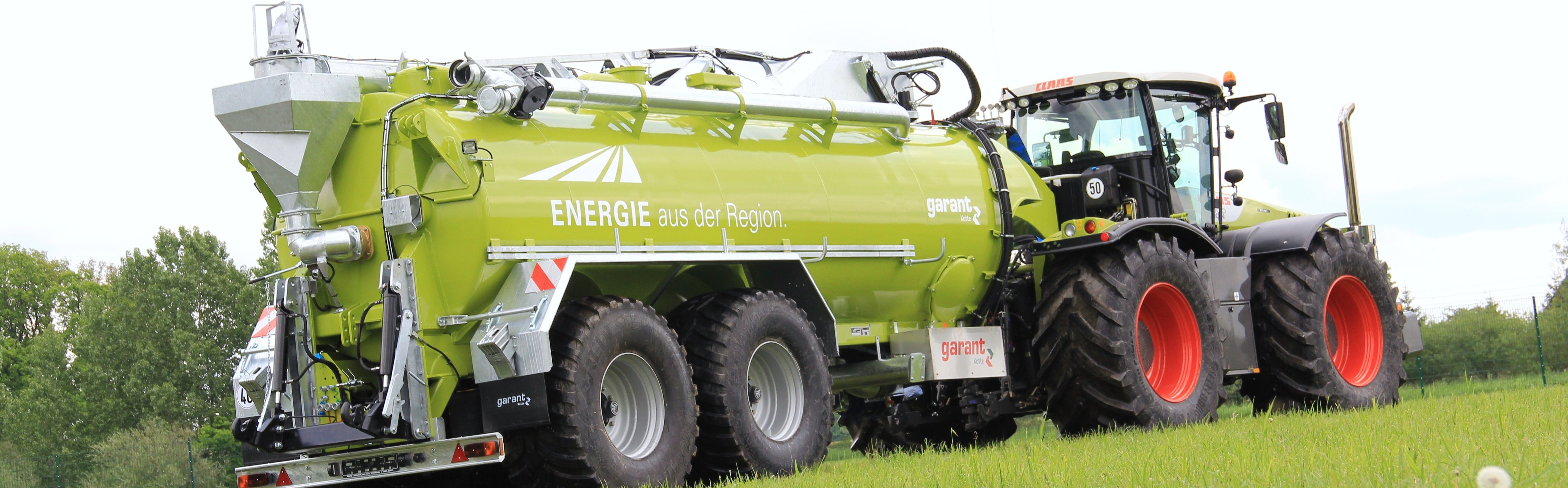Zelená cisterna s ''labutím krkem'' napojená na zelený traktor